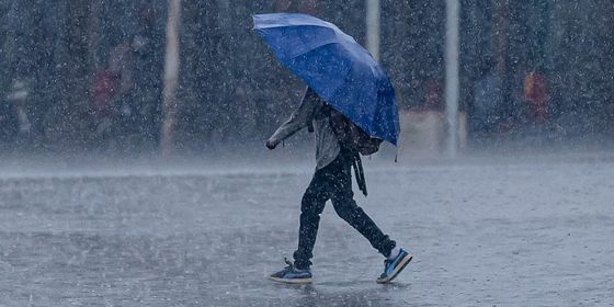 1200px-A_man_walks_through_heavy_rain.jpg