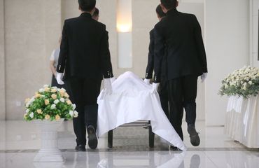 Funeral workers transporting body